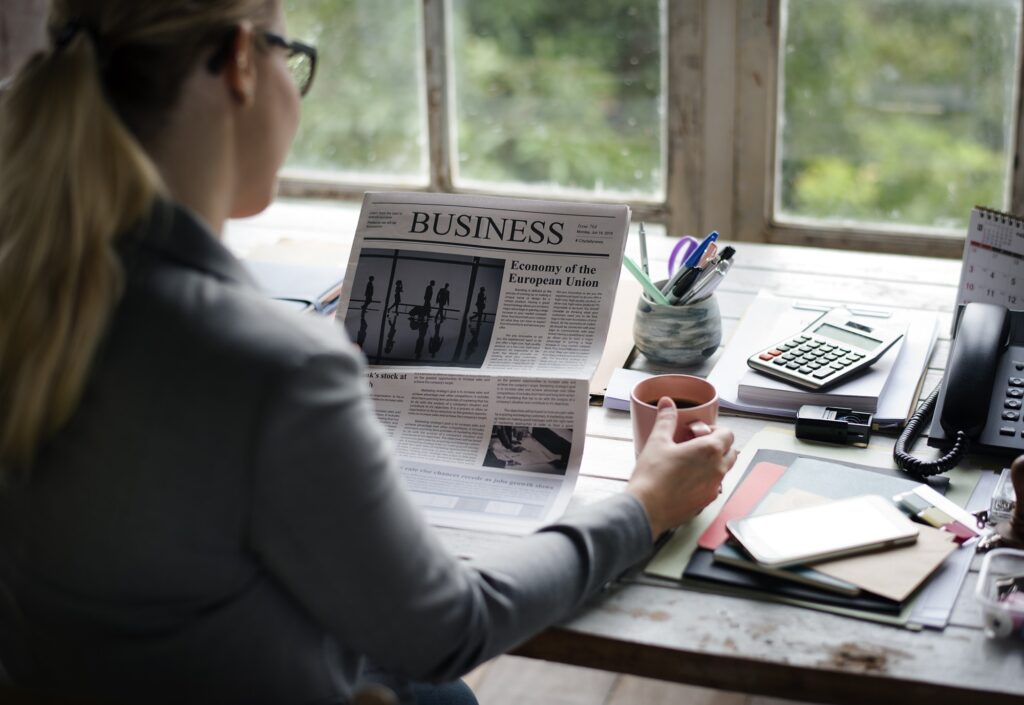 businesspeople reading newspaper at office updating news.jpg