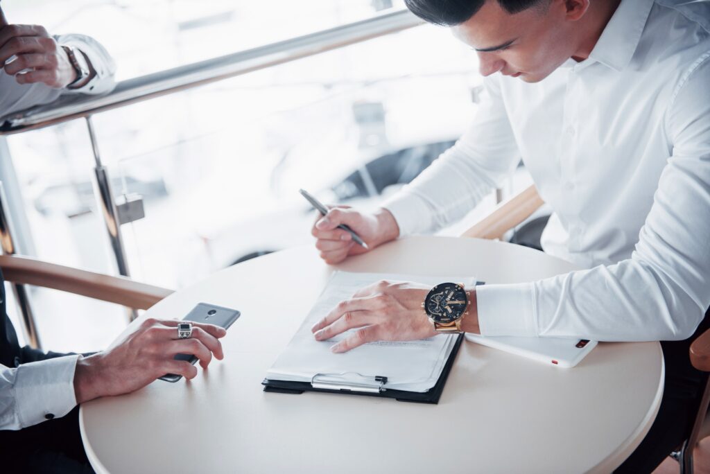 young man signs documents in the office successful sales.jpg