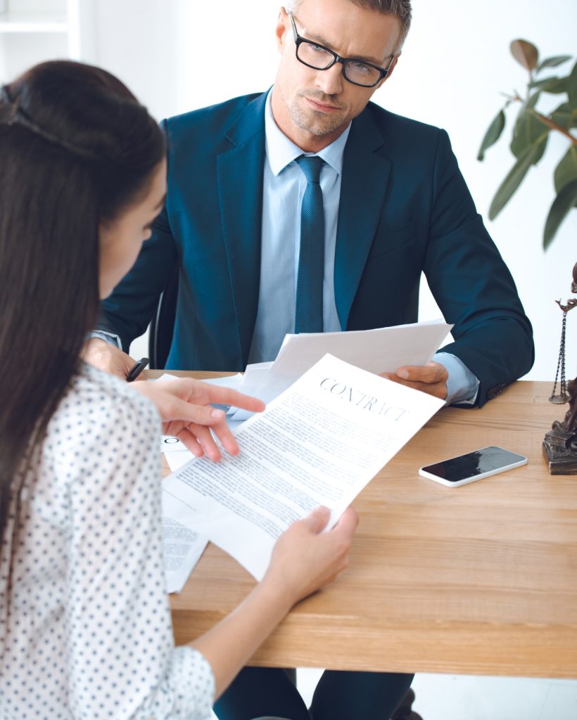 male lawyer looking at client reading contract.jpg