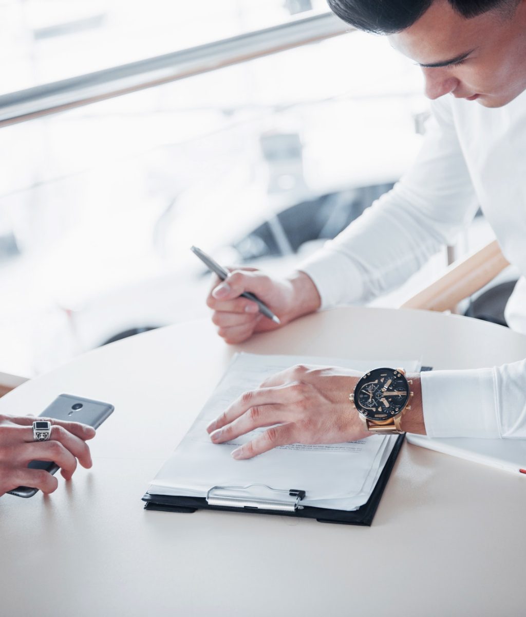 young man signs documents in the office successful sales.jpg